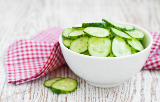 cucumber salad  in white bowl on a wooden background