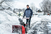 Young Snowblower Guy Clearing Snow From Suburban Driveway