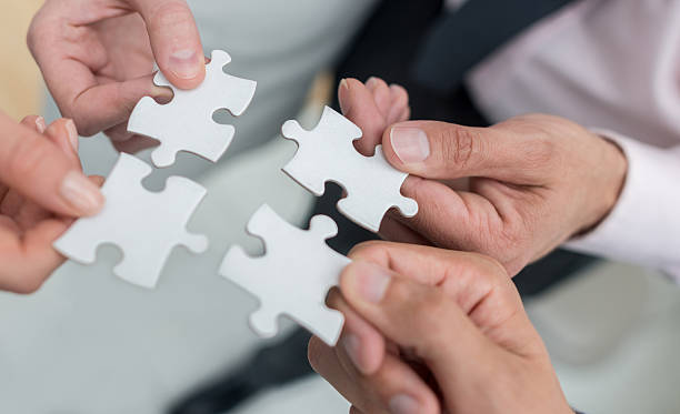 istock Business people assembling pieces of a puzzle 492498640
