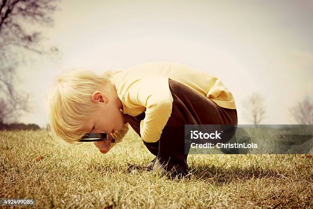 Young Child Looking Through Magnifying Glass Stock Photo - Download Image Now - Curiosity, Child, Magnifying Glass