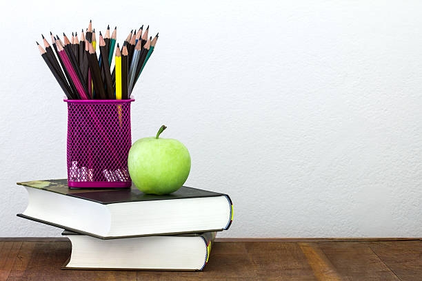 istock green apple with pencil box on wooden table 492508348