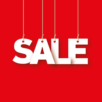 Sale - the word of the white letters hanging on the ropes on a red background