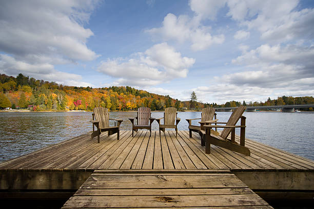 istock Wood Muskoka chairs on a lake deck in the Fall 492511708