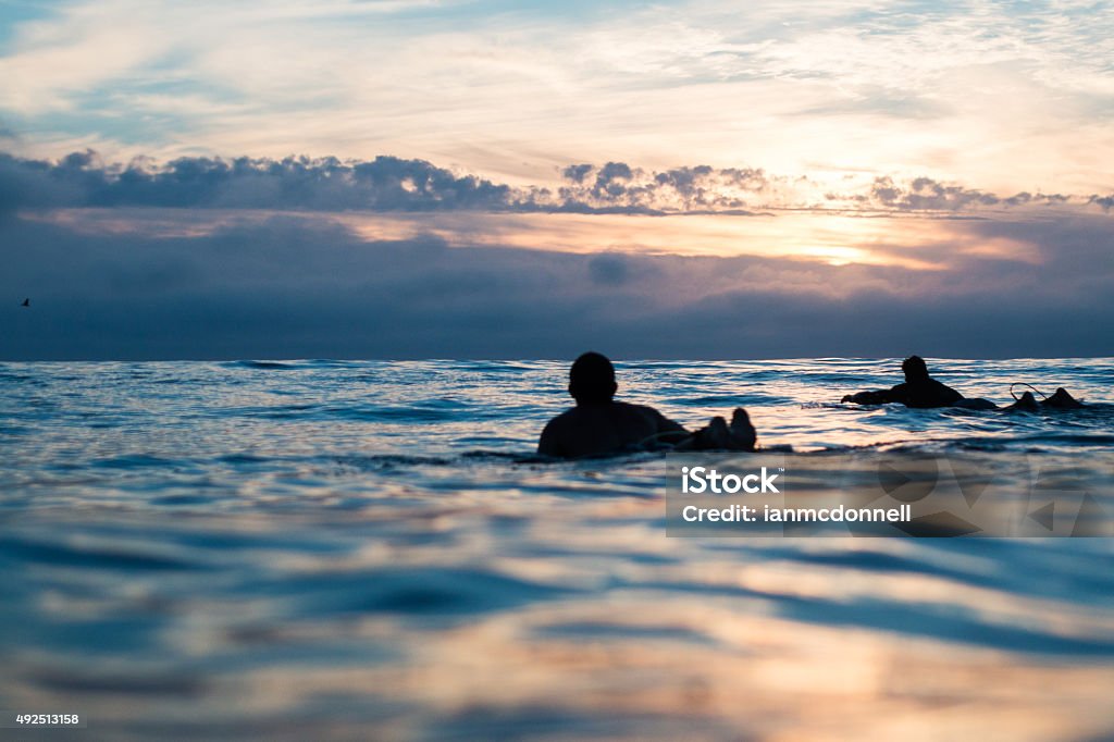 Sunset Surf Surfer paddling at sunset Surfing Stock Photo