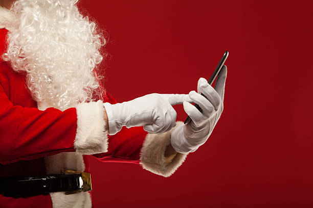 istock Modern Santa Claus using tablet pc over red background. Christmas 492515072