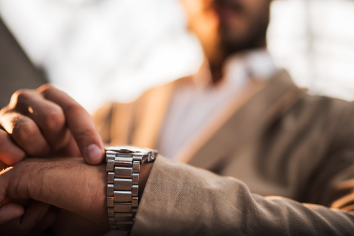 Close up of unrecognizable businessman checking the time on his watch.