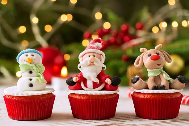 Photo of Three traditional decorated christmas cupcakes with festice back