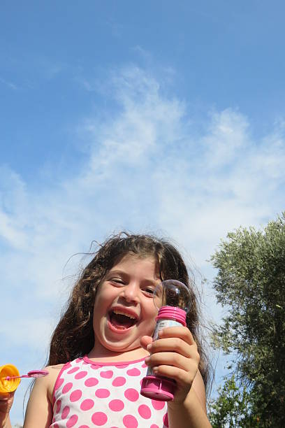 istock little girl playing with bubble wand 492517700