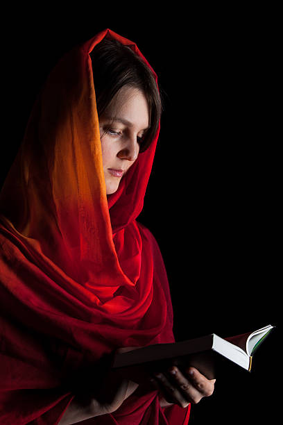 istock Woman reading a Bible in the night 492528807