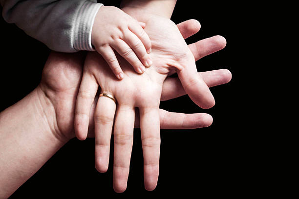 Hands of a family on black background stock photo