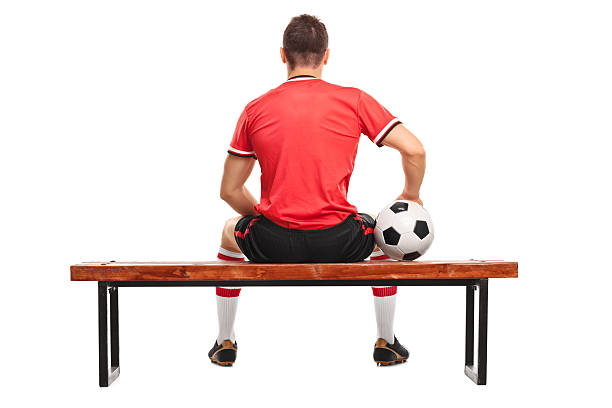 istock Football player holding a ball and sitting on a bench 492537232