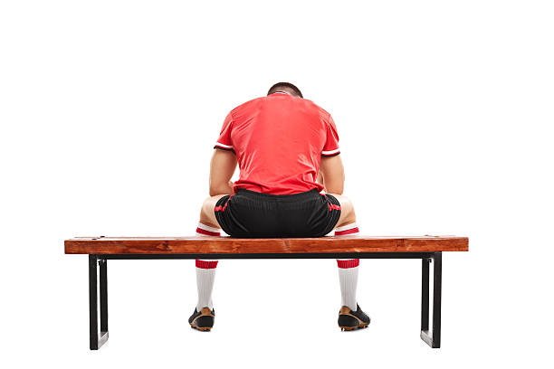 sad football player sitting on a wooden bench - 後備球員 個照片及圖片檔