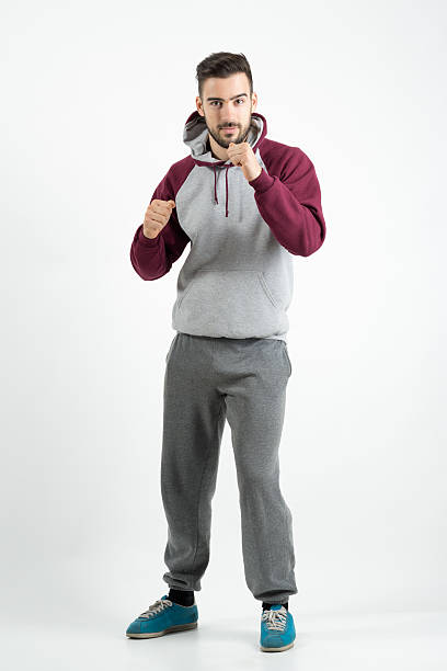 deporte hombre casual con boxeo gesto de mano sobre fondo gris - hooded shirt men macho hood fotografías e imágenes de stock