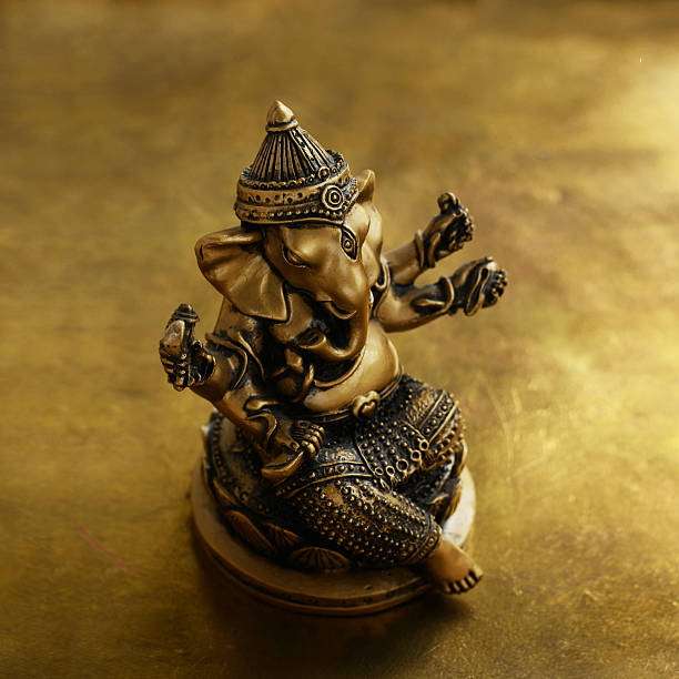 istock Ganesha bronze statuette over golden background 492545608