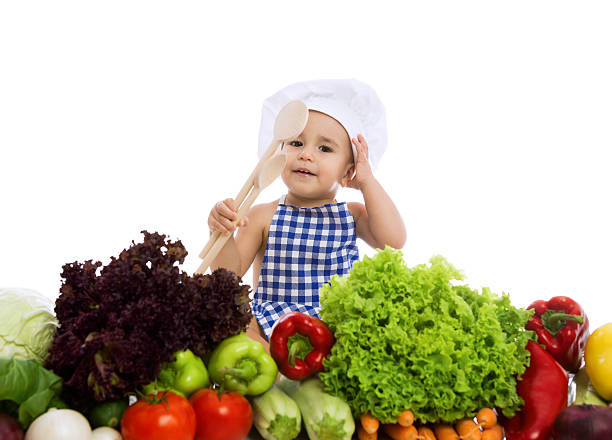 чудесные детские шеф-повар с здорового питания, овощи и держит scoo - baby carrot snack healthy eating small стоковые фото и изображения