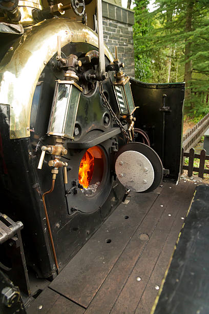 Footplate and open firebox on narrow gauge steam locomotive View into the footplate of narrow gauge locomotive on the Ffestiniog Railway, Gwynedd, Wales. United Kingdom firebox steam engine part stock pictures, royalty-free photos & images