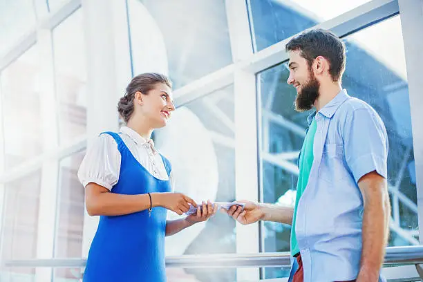 Photo of flight attendant giving a documents of male tourist