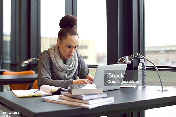 Woman using laptop for taking notes to study