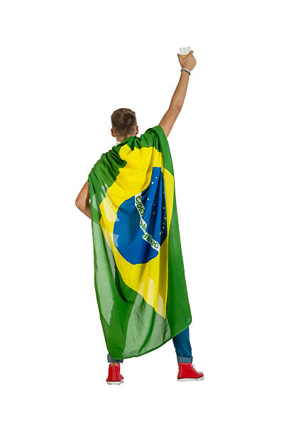 Young brazil supporter standing in super hero with beer cup stock photo