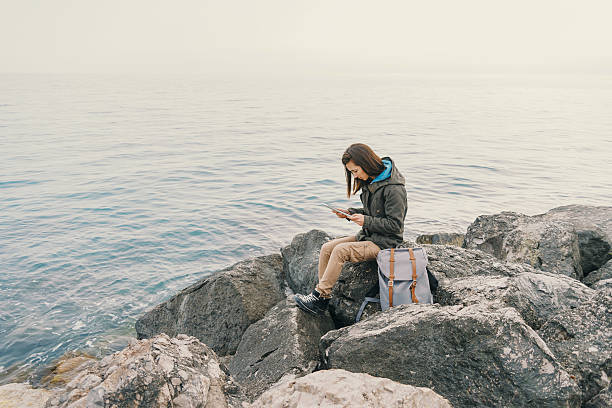 istock Traveler working on digital tablet on coast 492552360