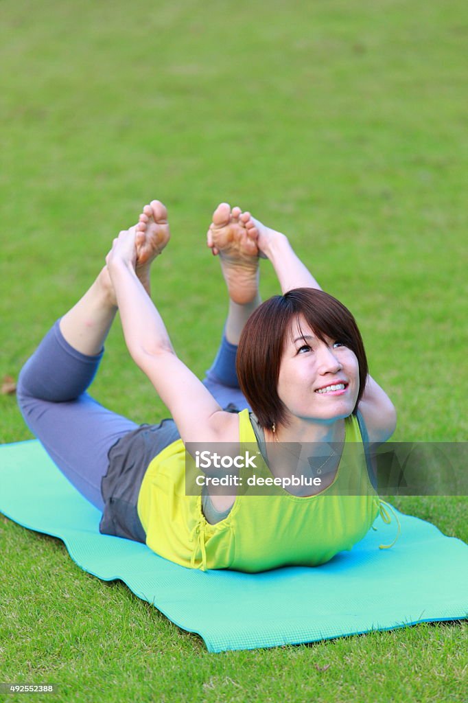 Japanese Woman Doing YOGA "bow pose" Portrait of Japanewe woman doing yoga exercise outdoor 2015 Stock Photo