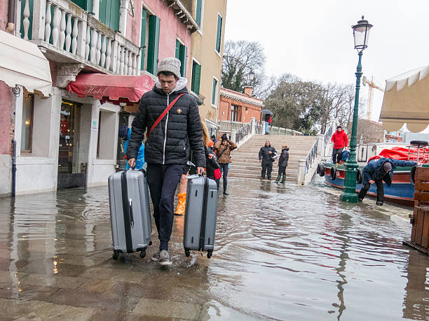 turysta odprowadza jego walizki do acqua alta, venice - acqua alta zdjęcia i obrazy z banku zdjęć