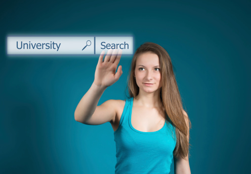 Happy girl pushing university button on search toolbar of virtual screen. Word University written in search bar on virtual screen.