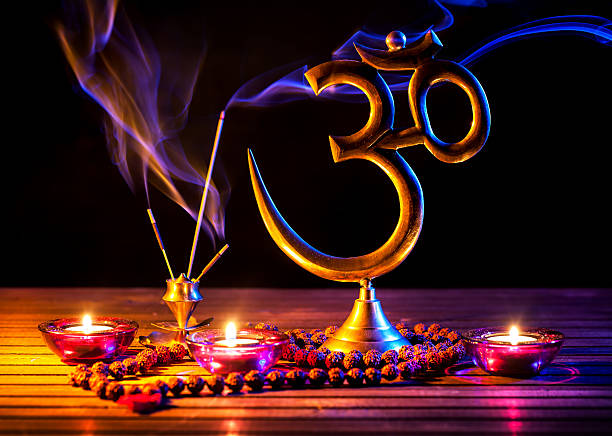 Om shanti Om symbol, incense smoke, candle and japa mala on wooden table at black background om symbol stock pictures, royalty-free photos & images