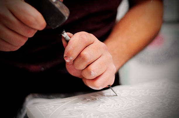 istock Manufacturer carving arabic script on marble plate on market, Morocco 492573193