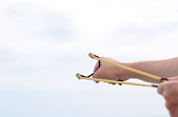 istock Hand Pulling Bands of his Stone Shooter Stick 492573198