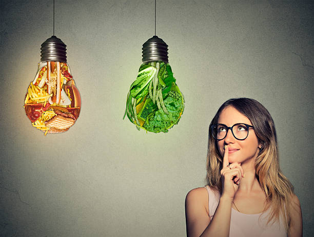 istock woman looking at junk food green vegetables shaped lightbulb 492573534