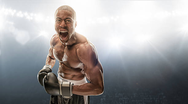 Boxer Getting Ready Male boxer standing in professional indoor floodlit boxing venue shouting at camera mixed martial arts photos stock pictures, royalty-free photos & images