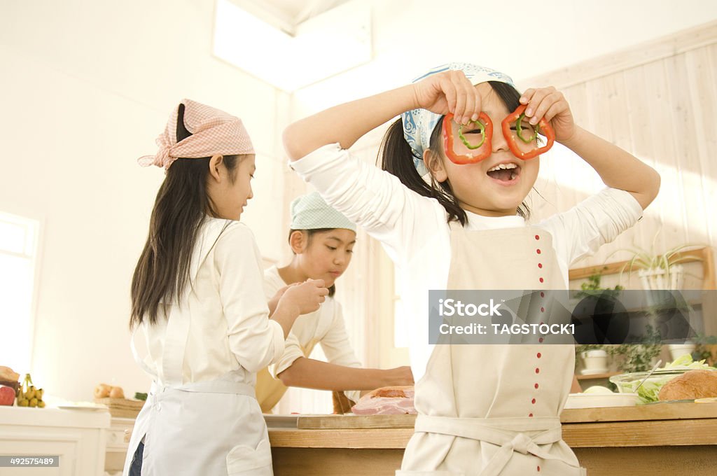 Japanese girls cooking playing with paprica in kitchen Japanese girls cooking in kitchen Asian and Indian Ethnicities Stock Photo