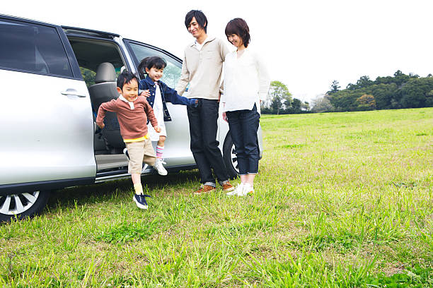 Family getting off a car in prairie stock photo