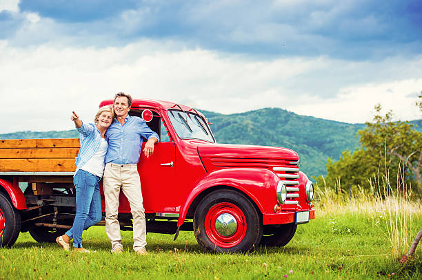 Senior couple with red car