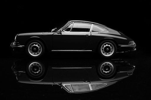 Beaconsfield, UK - October 7, 2015: A 1:18 scale model of a 1964 Porsche 911 made by Auto Art, set against a solid black background. Low key/black & white image.