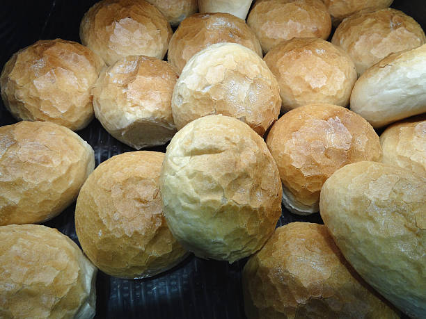 Image of freshly-baked white crusty bread rolls sold at bakery