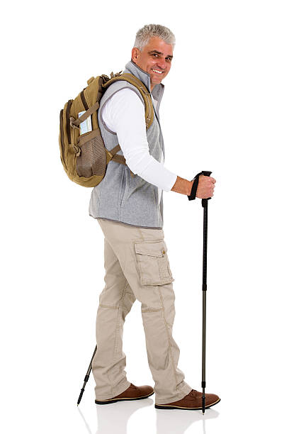 mid age man walking with trekking poles isolated on white