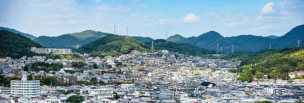 A panoramic view over the town of Hemiji in Japan with the Shiroyama mountains in the background. Logos removed.