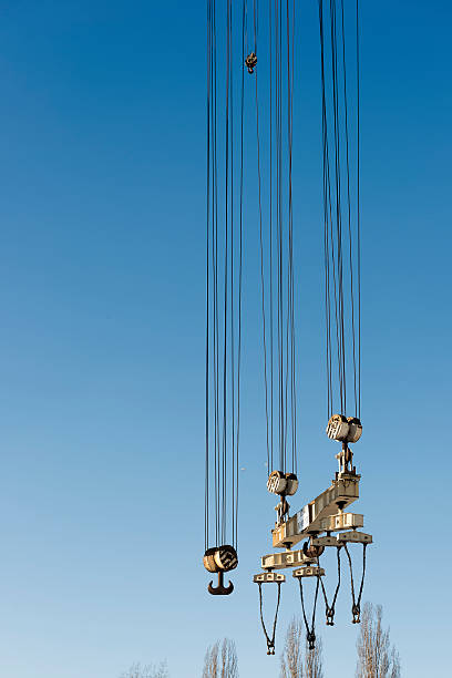 grande porto grous hooks penduradas em cordas de aço. - crane shipyard construction pulley - fotografias e filmes do acervo