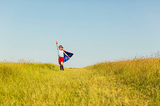 istock Young Girl dressed as Superhero Running in Grass 492585566