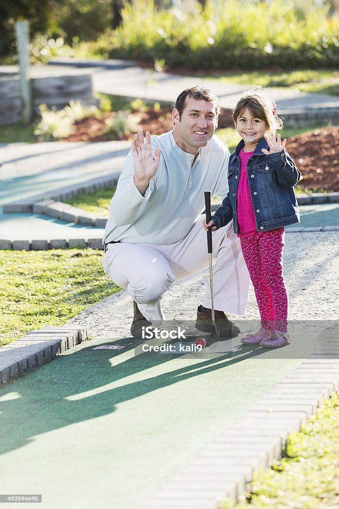 Petite fille avec le Père jouer au golf miniature - Photo de Golf miniature libre de droits