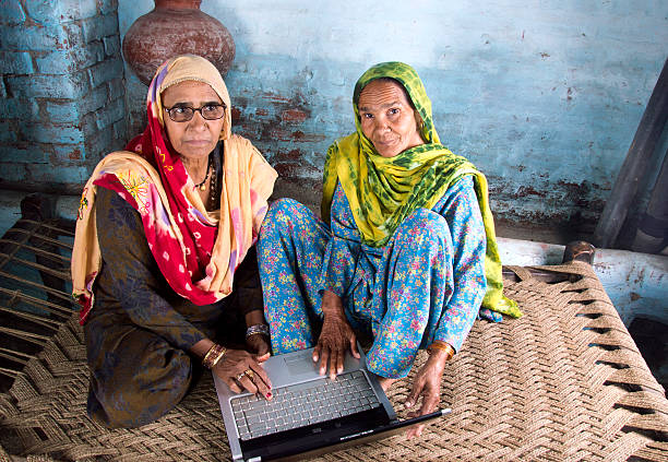 deux femmes âgées à l'aide d'un ordinateur portable - women poverty senior adult mature adult photos et images de collection
