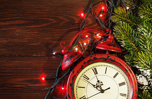 istock Christmas alarm clock, tree branch and lights 492597060
