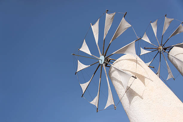 Tilted image of two white greek windmills Tilted image of two white greek windmills against a clear blue sky on the island of Crete. herakleion photos stock pictures, royalty-free photos & images