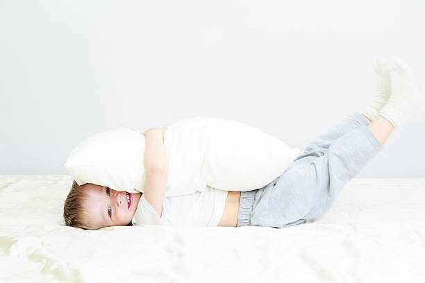little child playing in bed stock photo