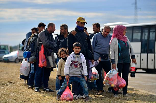 Tovarnik, Croatia - October 5, 2015:  Croatian police assist refugees from Syria, Afghanistan and Iraq get into train which will go to Hungary.
