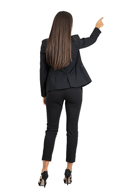 Rear view of businesswoman pointing on her right side stock photo