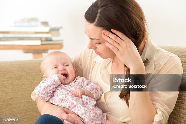 A Madre Con Bebé Dentición Malestar Foto de stock y más banco de imágenes de Mordedor - Mordedor, Bebé, Llorar