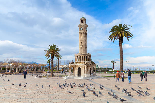 Doves and walking people on Konak Square, Izmir Izmir, Turkey - February 12, 2015: Doves and walking people on Konak Square near the historical clock tower izmir photos stock pictures, royalty-free photos & images